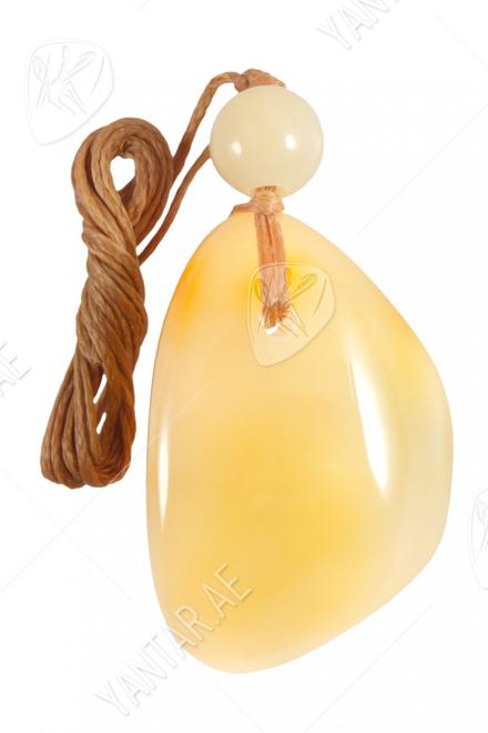 Pendant made of polished amber stone and amber ball